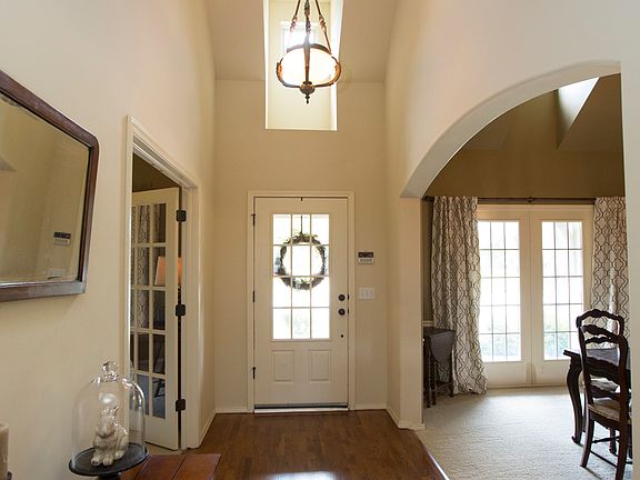 Inviting Foyer boasts two story soaring ceilings complete with designer lighting and rich hardwood floors.