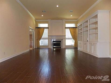 Large living room with wood like tile, crown molding and cus