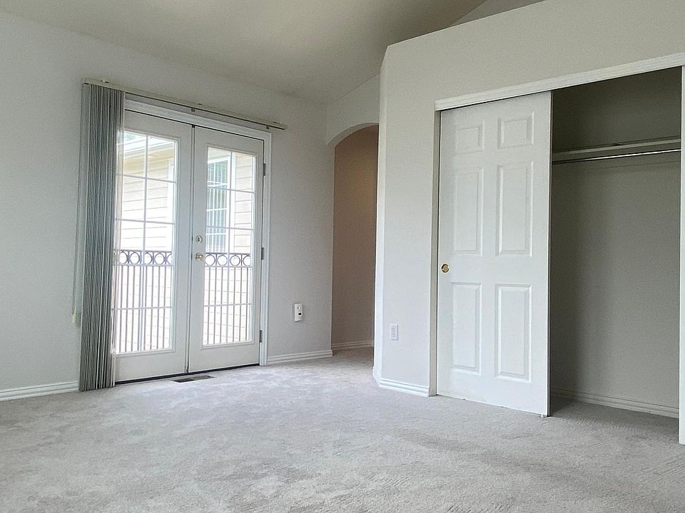Master bedroom with one of two, large closets, ceiling fan, patio balcony doors.
