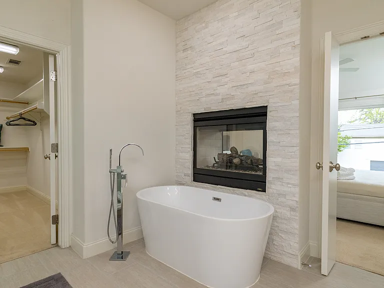 Freestanding tub with a double-sided fireplace