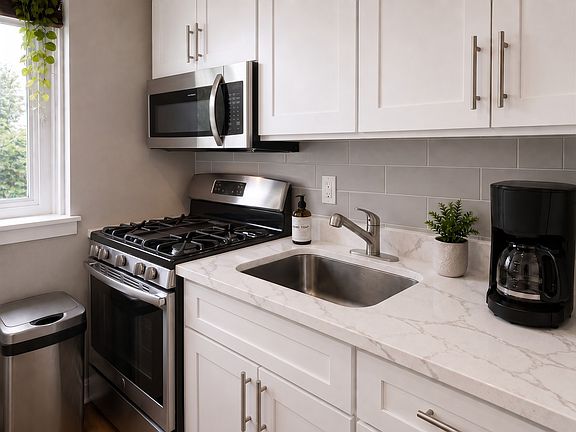 Elevate your culinary experience in this modern kitchen at Patchogue Village at Maple. Featuring stainless steel appliances, sleek cabinetry, and elegant countertops, it''s the perfect space for meal preparation or entertaining. Explore your new home today
