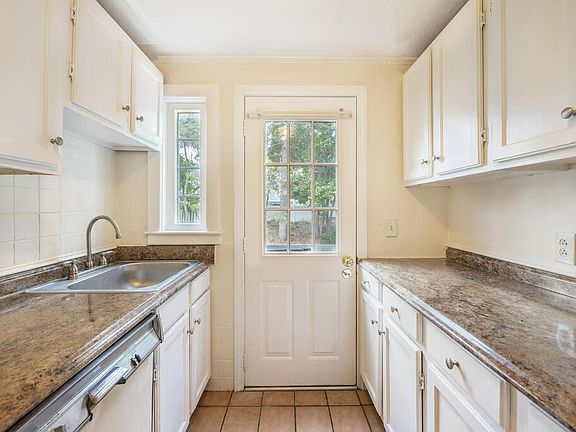 Galley kitchen with fridge, dishwasher, and sink