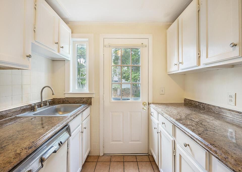 Galley kitchen with fridge, dishwasher, and sink