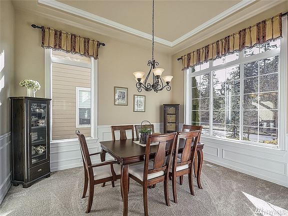 Formal dining room off of the entry, tray ceiling, beautiful wainscoting walls with chair-rail moldings.