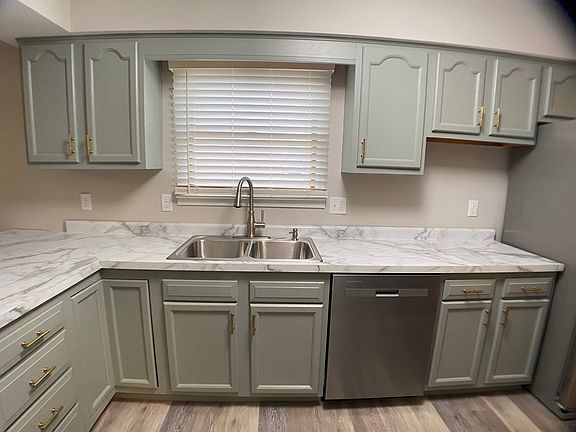 Spacious Kitchen that has painted cabinets with brushed gold pulls and new marbled countertop. Also new stainless steel appliances.