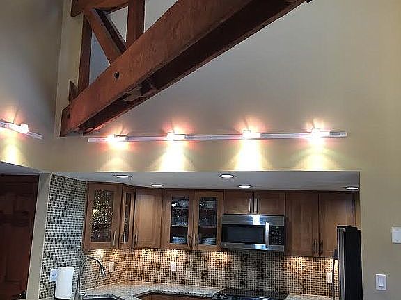 Vaulted Ceiling with wood stained beam and track lighting
