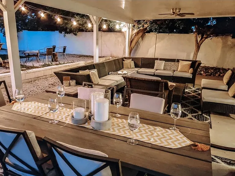 Outdoor living area has a patio table for 6 and a large sectional sofa for up to 10 people