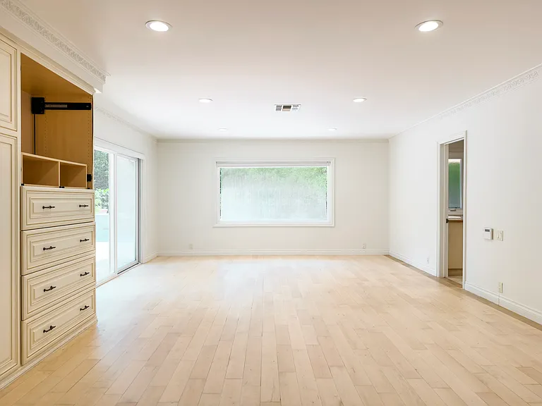 Unfurnished bedroom with a built-in wardrobe and private patio access opens to an ensuite in this Beverly Hills luxury rental at 1094 Garden Lane, 90210.