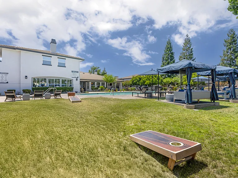 Next to our pool deck, a grassy area with cornhole boards invites friendly outdoor fun with neighbors.