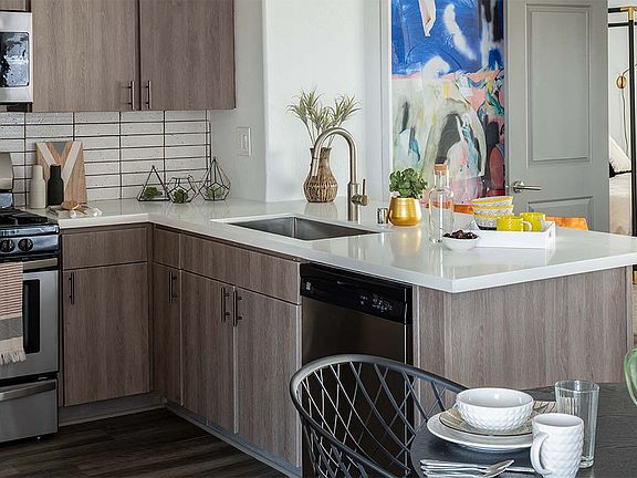 Apartment Kitchen with Stainless Steel Appliances, quartz counters and wood floors.