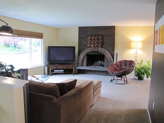 Light and bright living room with fireplace and new carpet.