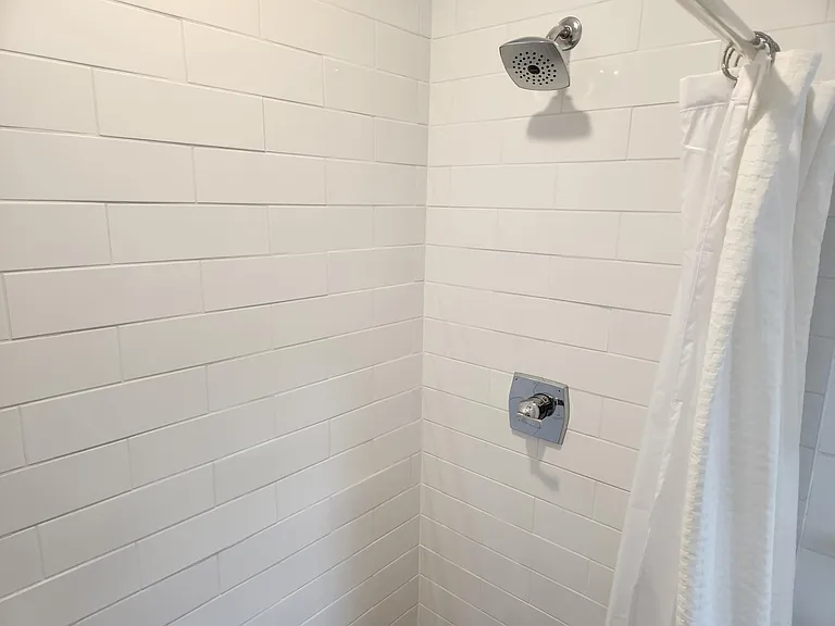 Large subway tiled shower with new fixtures.