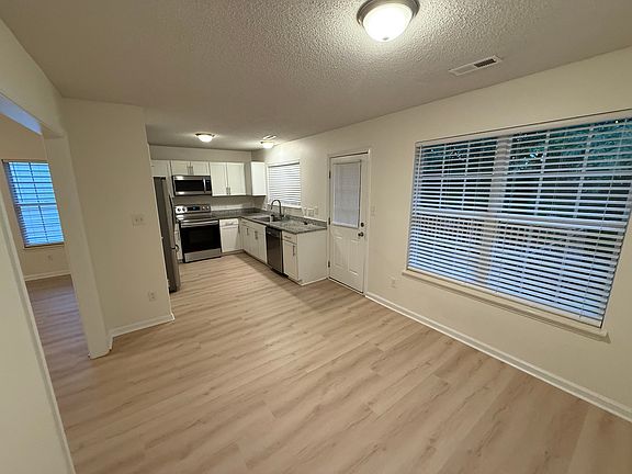 View of kitchen from dining area - stainless steel appliances and granite countertop