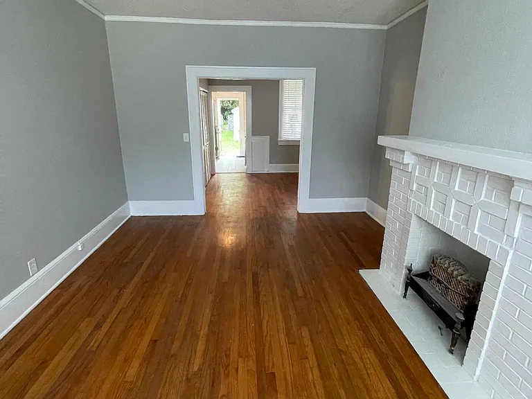 Living Room. Photo also shows dining room and kitchen beyond living room, with kitchen opening to back yard.