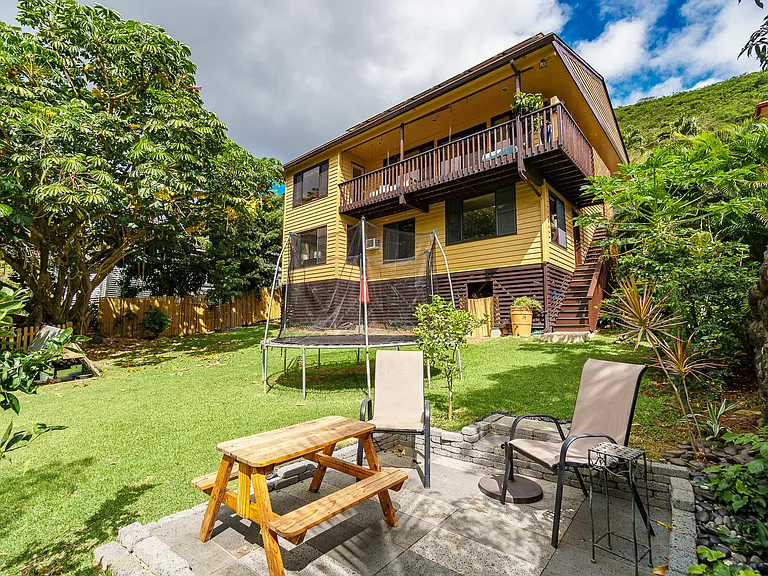 Fenced in backyard, fruit trees, lava stone patio, trampoline.