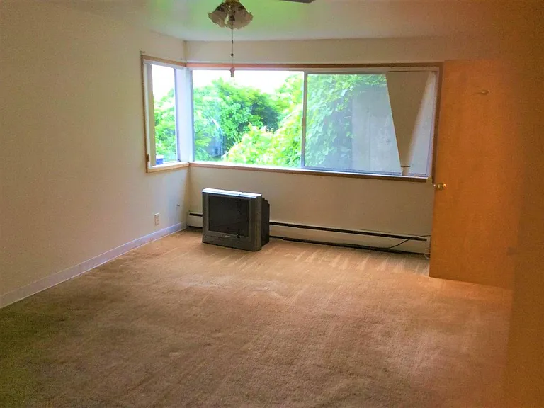 Master bedroom with ceiling fan and old TV/VCR that can be used or disposed of by tenant.