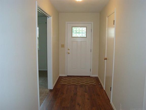 Front door entry area with closet to right. Living room through doorway on left.