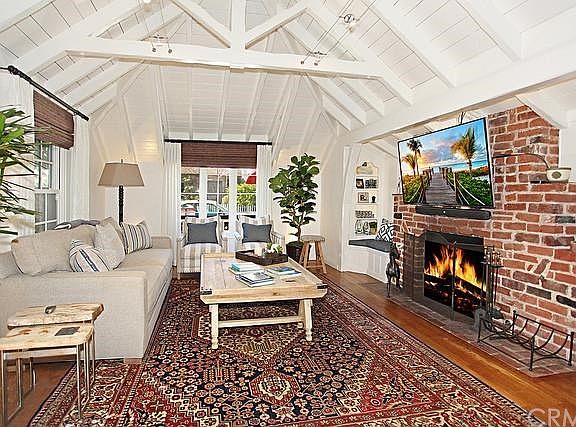 Inviting living room with hardwood floors, beamed ceiling and fireplace