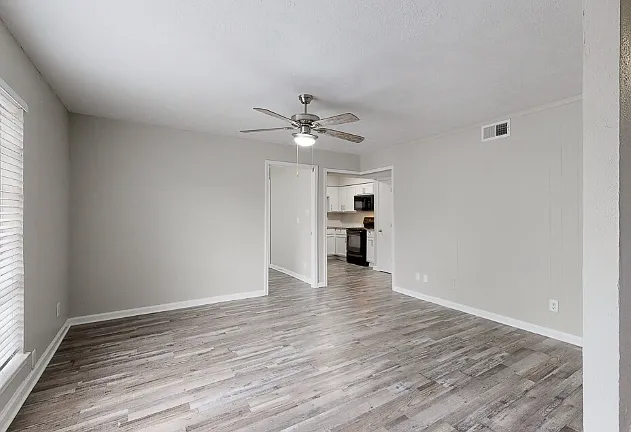 Spacious living room with wood-style flooring and natural light