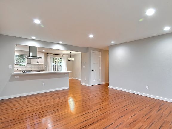 View of kitchen and main living area with seating for 4 at the kitchen peninsula.