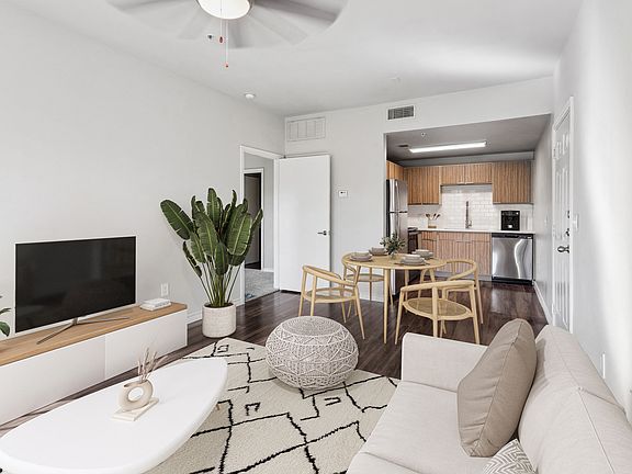 Spacious living room with renovated kitchen finishes