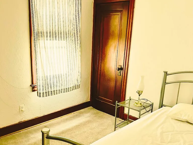 View of the room from the doorway, showing a bright and comfortable layout. Includes a walk-in closet for extra storage.The room is furnished with a bed frame, mattress, and a nightstand for added convenience and comfort.