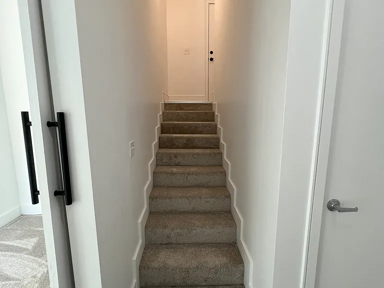 Stairway from garage entry landing to first floor bedroom