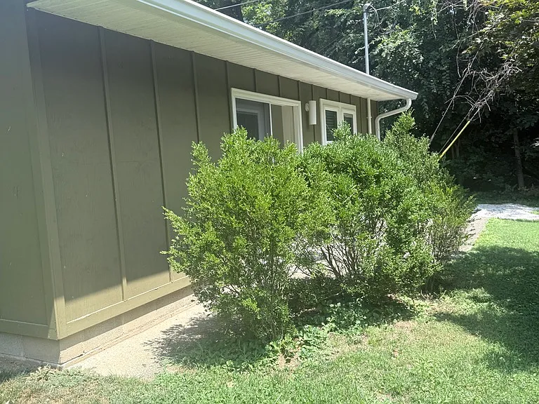 Closer view of your door into the carriage house with patio screened by shrubbery.