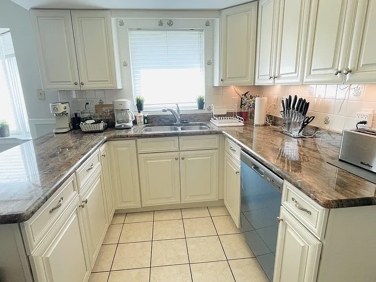 Part of the kitchen with the double sink, garbage disposal, under cabinets lighting and stainless still appliances - new in 2023.