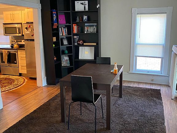 Huge Dining Room open to kitchen and living room with large windows and built-in shelving, and glass french doors.