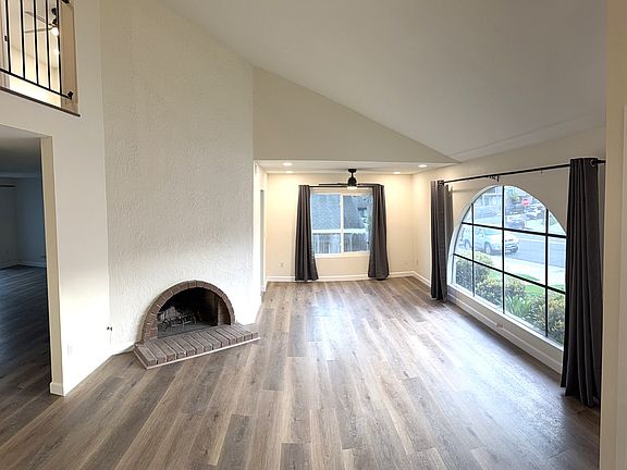 Living room with fireplace and adjacent dining room viewed from entry.