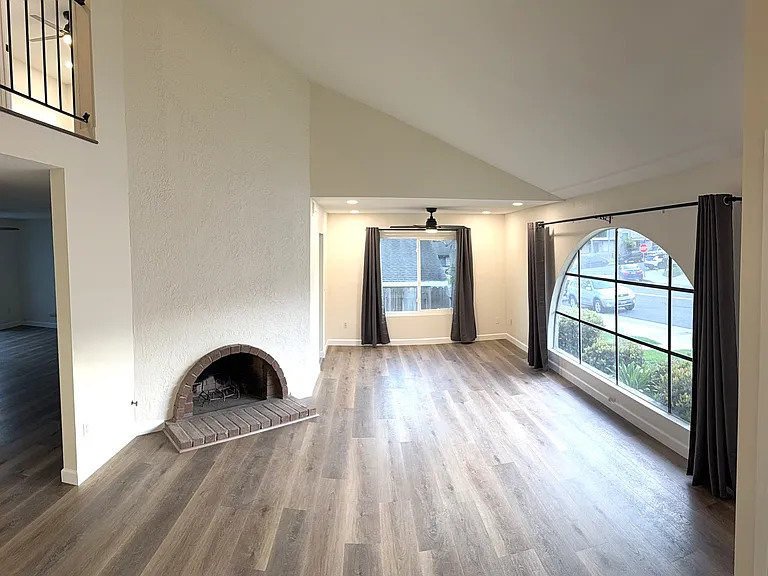 Living room with fireplace and adjacent dining room viewed from entry.