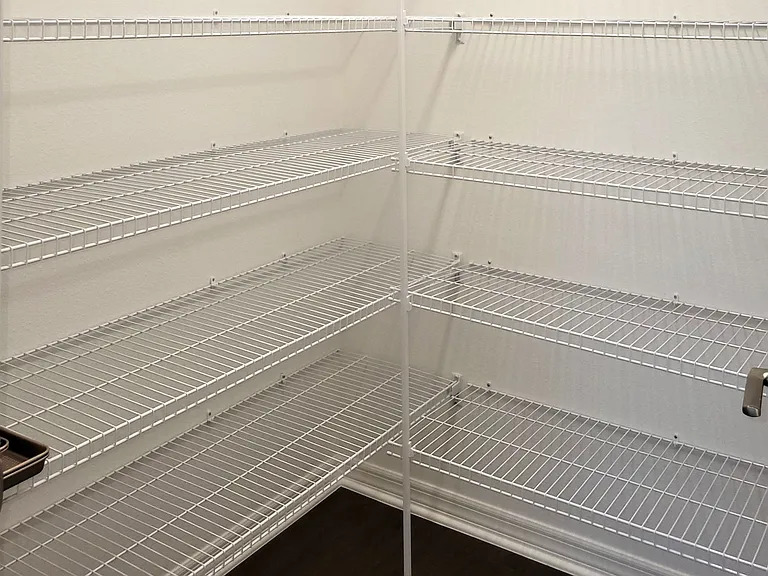 A Walk-in Pantry with Wall-to-Wall Shelving for Food and Equipment Storage.