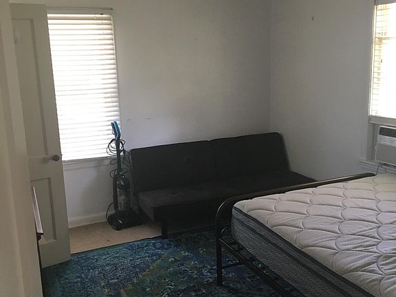 Entering bedroom. Bed, loveseat, vacuum included. Bathroom is to the left.
