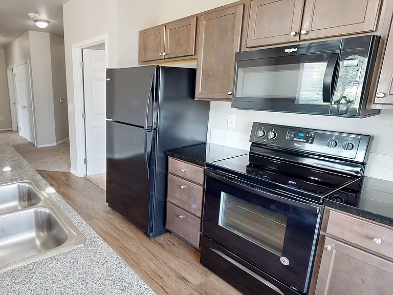 All kitchens include a dishwasher, refrigerator, microwave, and electric range. Some homes feature stainless steel while others have black appliances.