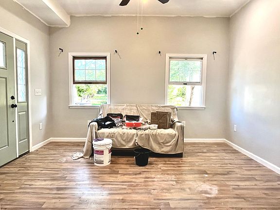 Living room with 10ft ceilings. Still finishing paint and will clean floors.