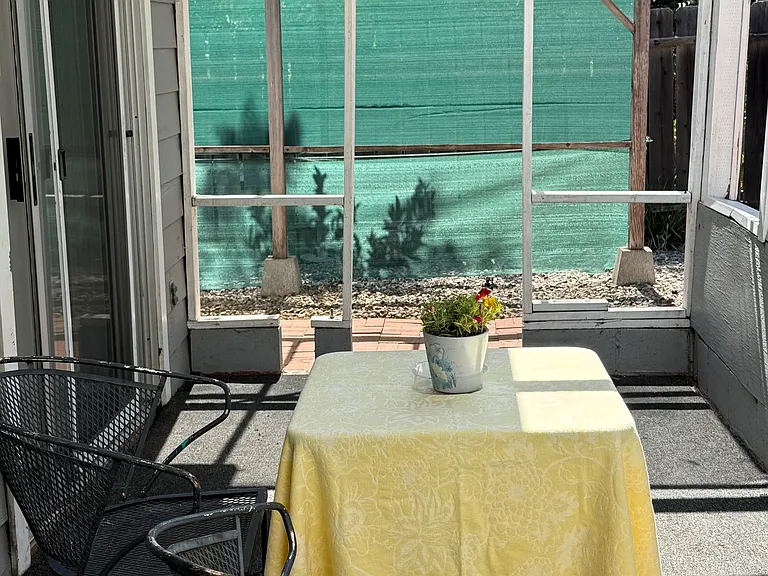 Covered patio area (reach via sliding glass doors from the main living area) overlooking the studio's private backyard space.