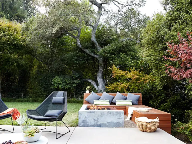 Fire pit with built in bench area for seating and separate seating area on patio right outside house