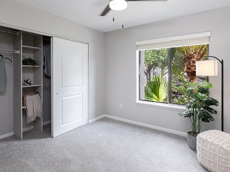 Bedrooms featuring plush carpeting, large windows, and a generous closet with built-in shelving for easy organization.