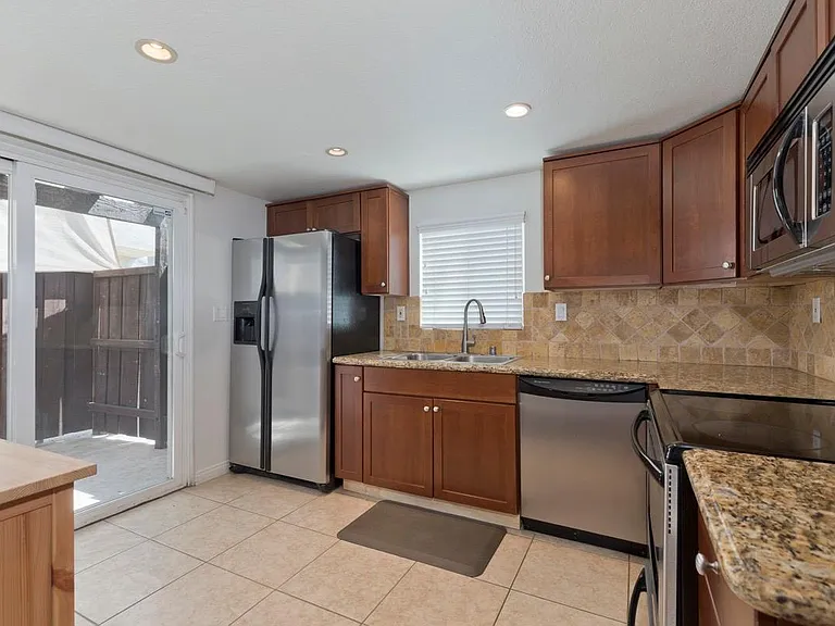 Kitchen with stainless steel appliances and sliding glass door to private patio