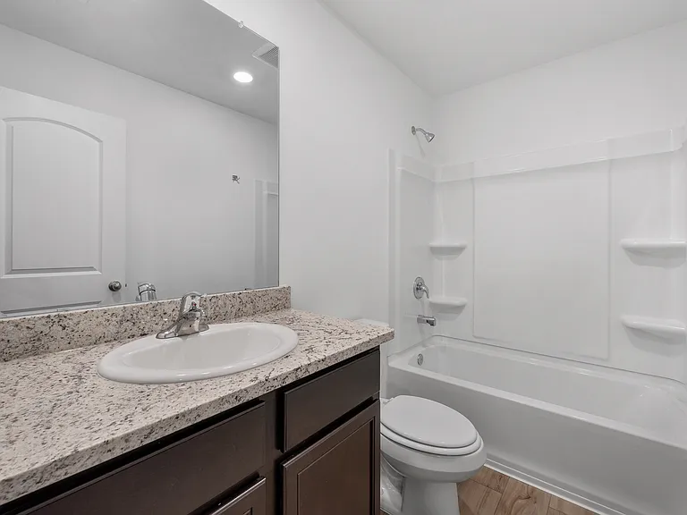 Secondary bathroom with granite countertops.