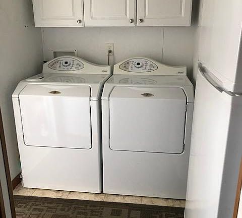This is the back entrance off the covered back deck. Matching, full size Maytag, front loading, washer and dryer provide convenience and washday savings. The kitchen refrigerator is seen on the right in this picture.