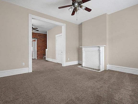 Front door looking into living room with fireplace and mantle