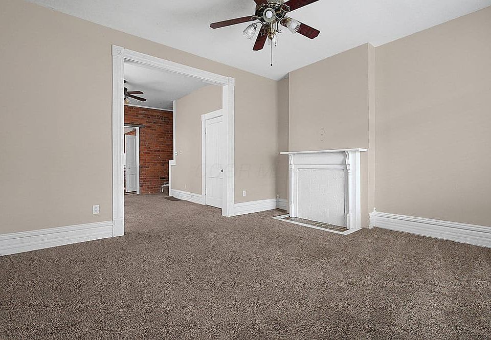 Front door looking into living room with fireplace and mantle
