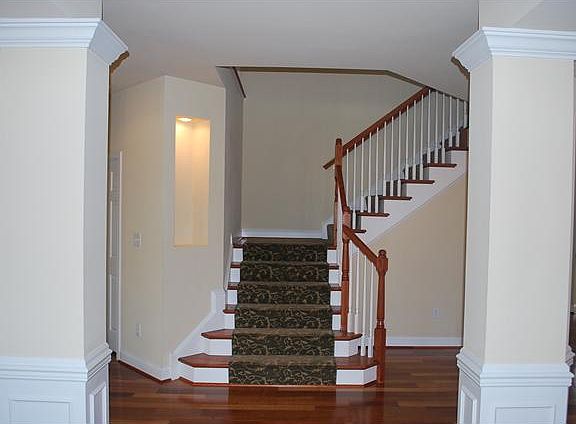 Foyer with Columns and Hardwood Staircase