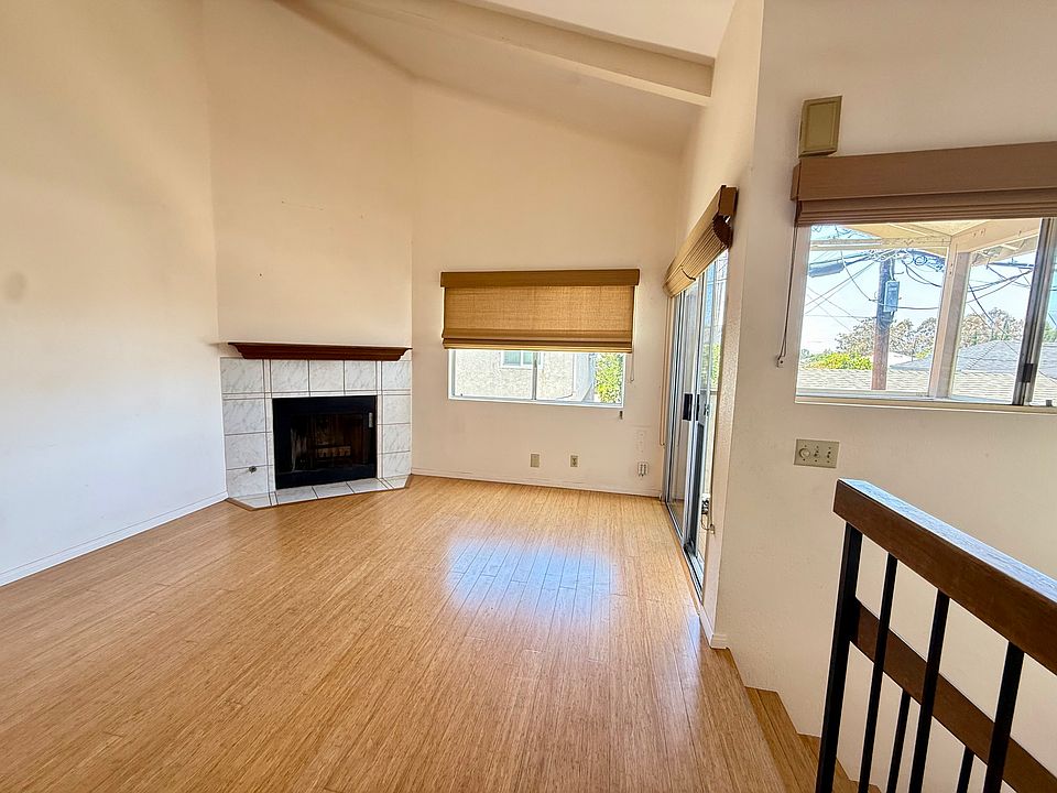 Upstairs living room with vaulted ceiling and wood fireplace.