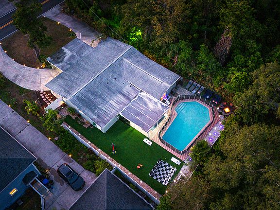 Nighttime view of the full property, including the front and backyard. Solar lights illuminate the exterior after dark.