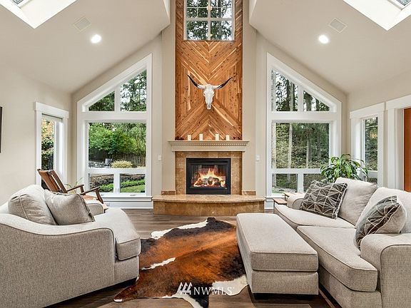 Main floor living room can't help but be called great! The vaulted ceilings and skylights keep it bright even though you are nestled in the trees. Huge windows allow the amazing property in. You'll love relaxing or entertaining in here!