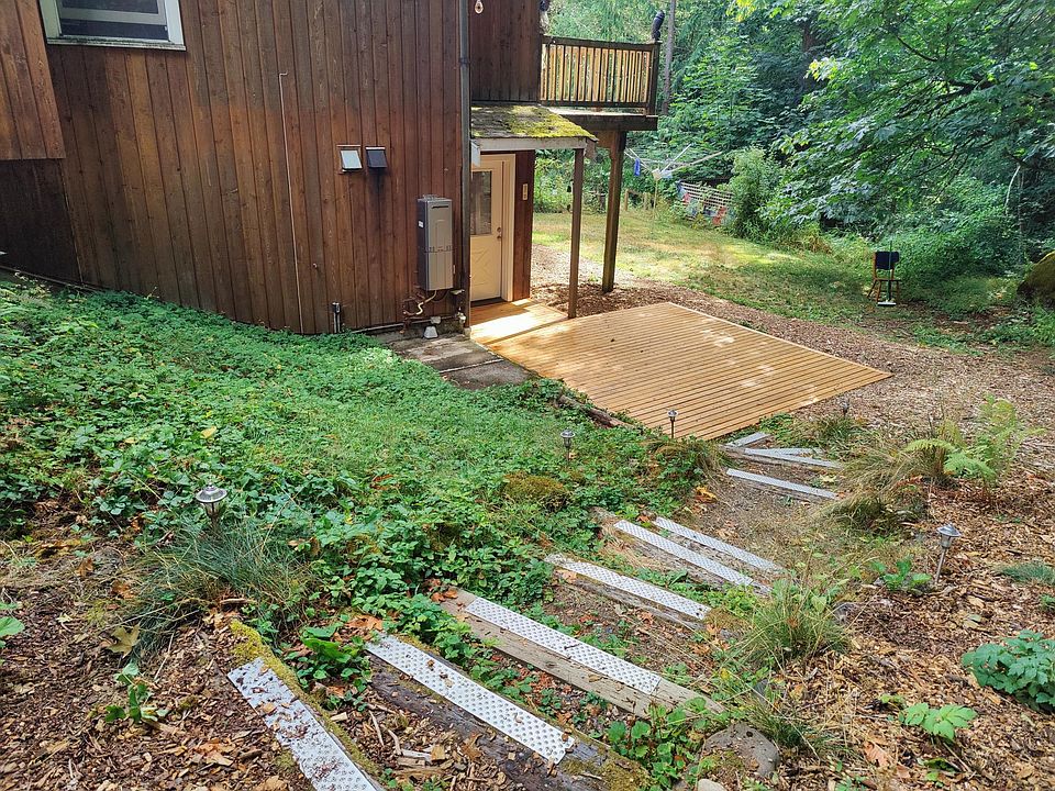 Private entrance to apartment with cedar deck. Walk from your dedicated parking spaces alongside a hillside covered in tumbling strawberry plants that produce tiny, sweet berries.