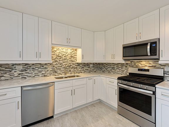 All new kitchen with quartz counters, stainless steel appliances, new flooring and white cabinetry.